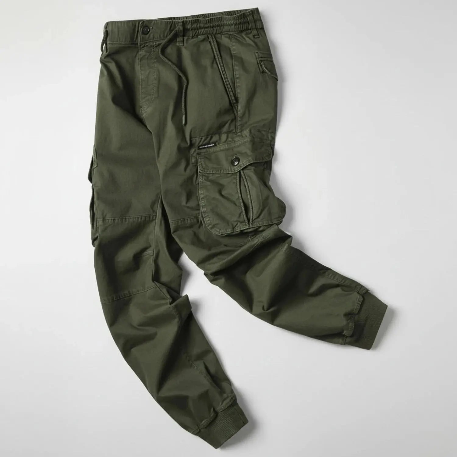 View of relaxed utility summer cargo jogger pants in olive green, featuring multiple pockets and a comfortable waistband