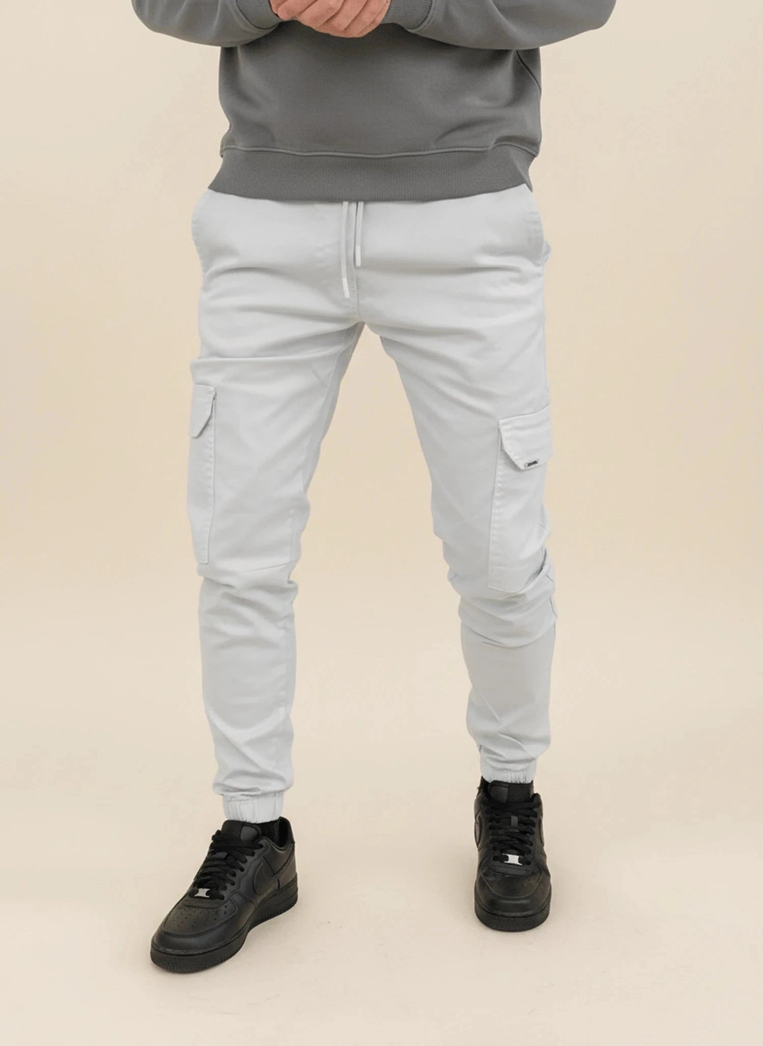 View of modern slim tapered cargo pants in olive green, featuring multiple pockets and a soft cotton blend material