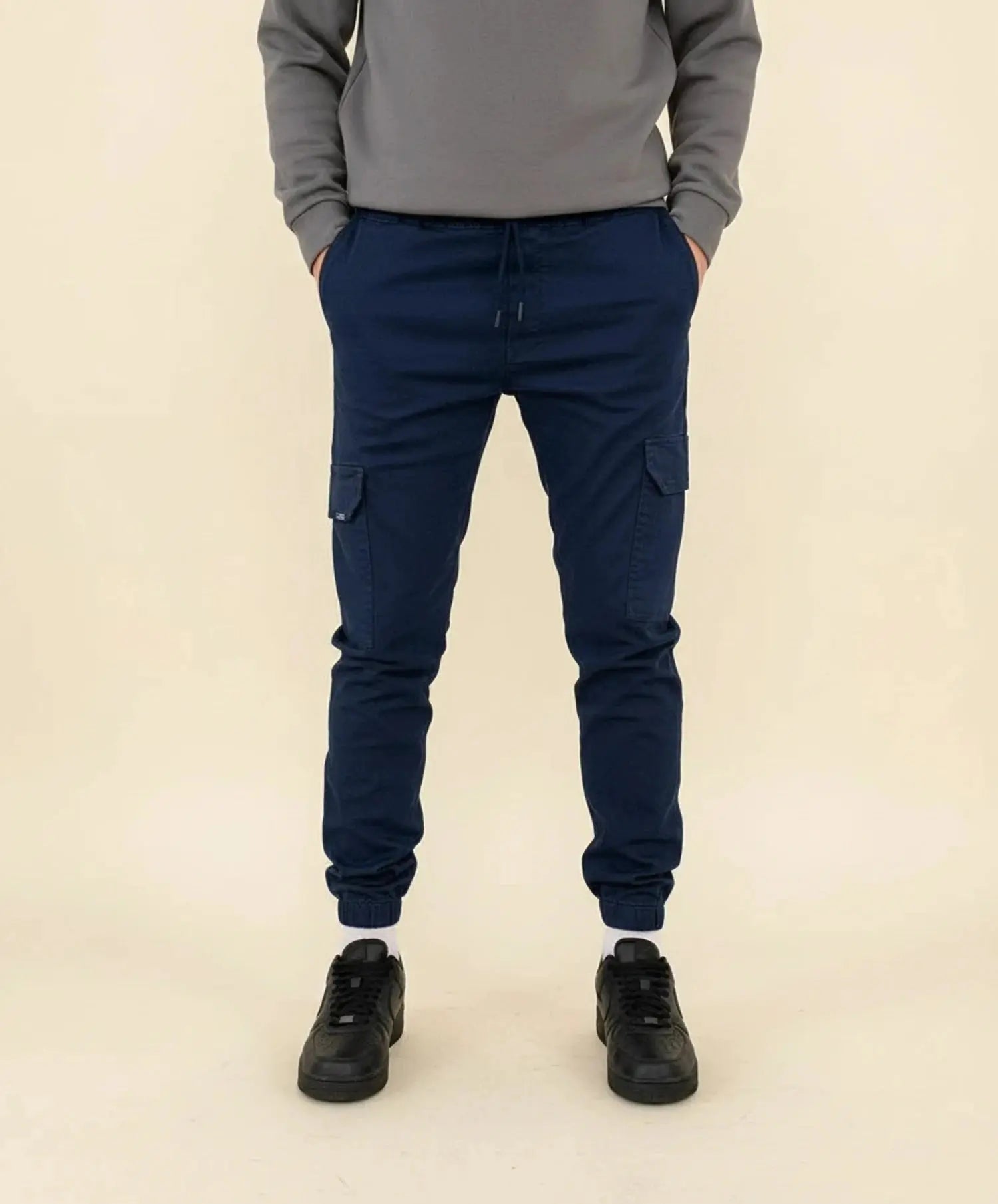 View of modern slim tapered cargo pants in olive green, featuring multiple pockets and a soft cotton blend material