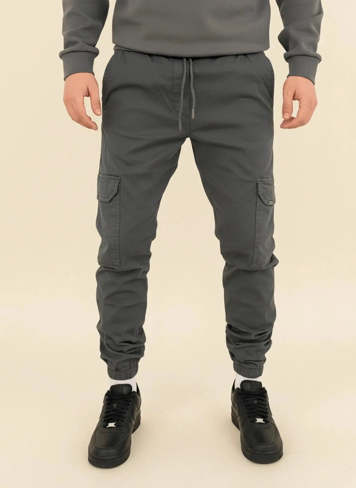 View of modern slim tapered cargo pants in olive green, featuring multiple pockets and a soft cotton blend material