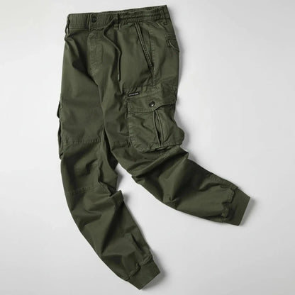 View of relaxed utility summer cargo jogger pants in olive green, featuring multiple pockets and a comfortable waistband