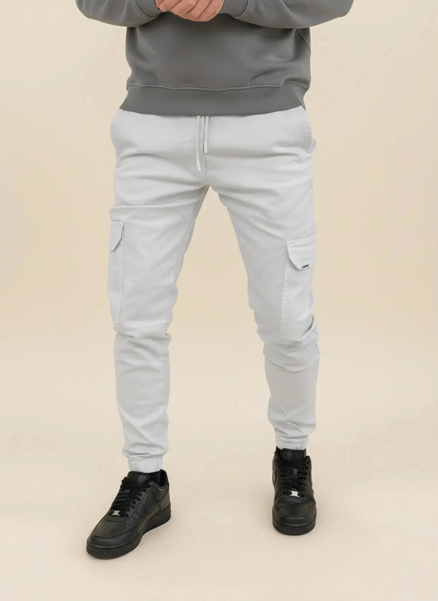 View of modern slim tapered cargo pants in olive green, featuring multiple pockets and a soft cotton blend material