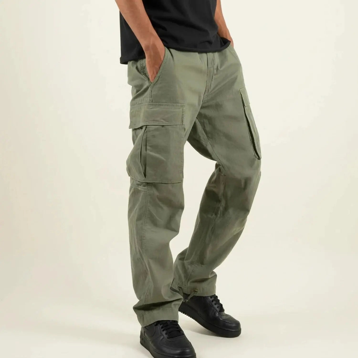 View of relaxed fit cargo pants in olive green, featuring multiple pockets and a comfortable waistband