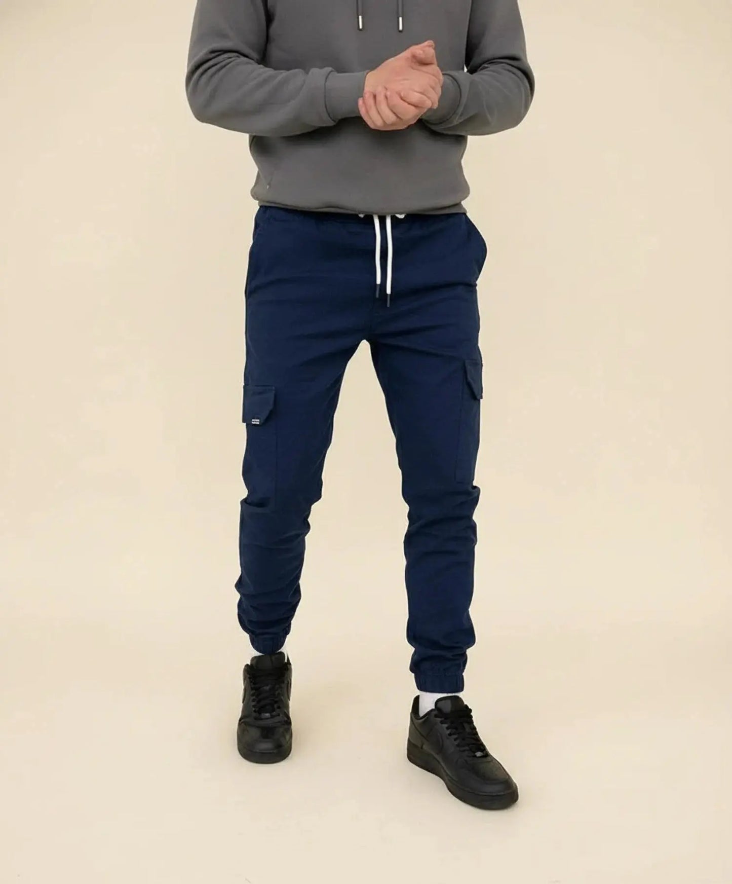 View of modern slim tapered cargo pants in olive green, featuring multiple pockets and a soft cotton blend fabric