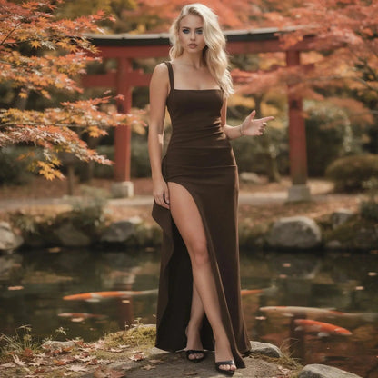 Woman wearing a brown slim fit maxi dress with a high slit, standing near a pond in autumn