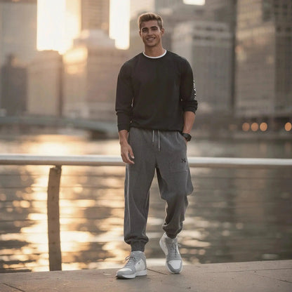 Man wearing grey corduroy joggers and black sweatshirt, standing