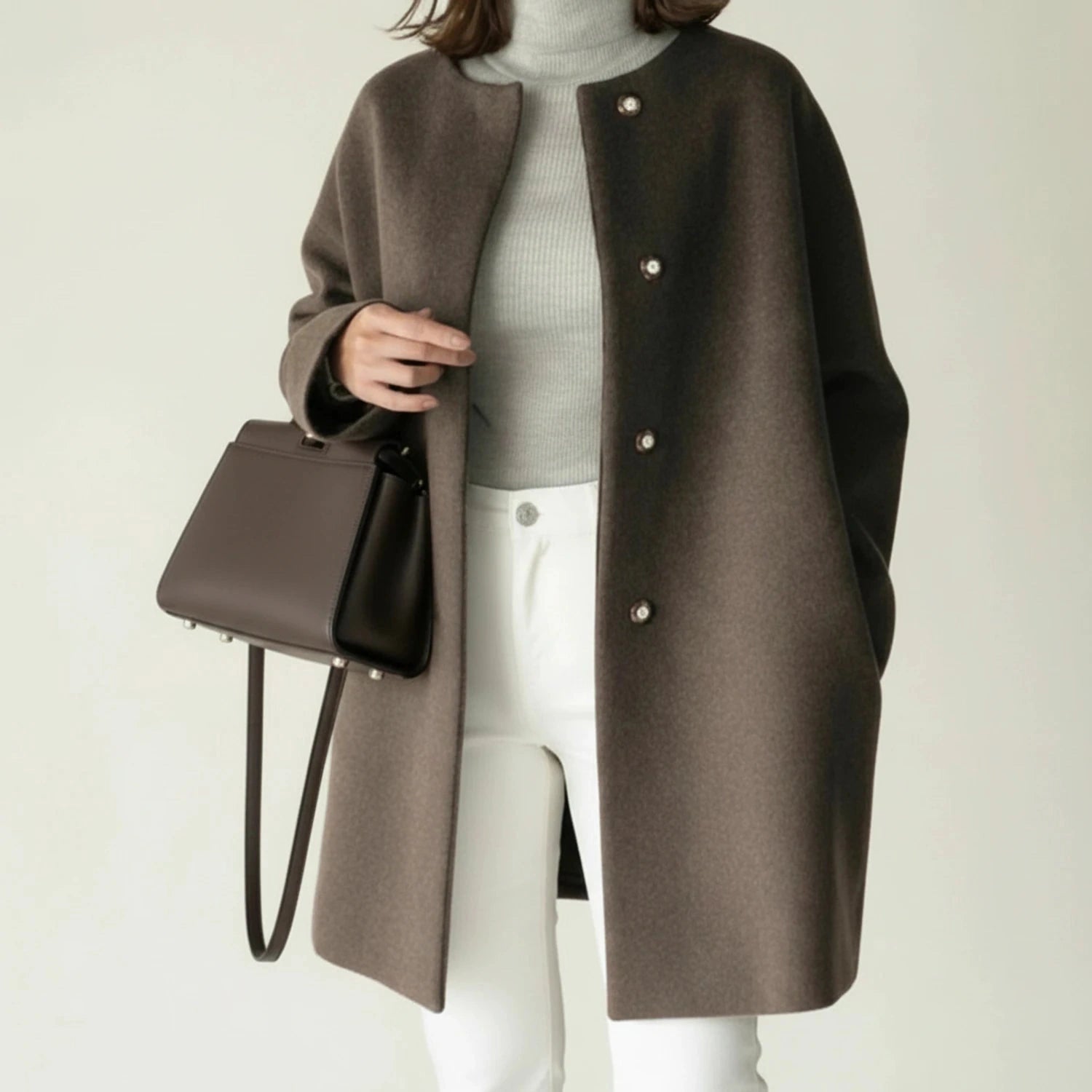 View of an elegant minimalist winter coat in deep charcoal gray, featuring a tailored silhouette and a mid length cut