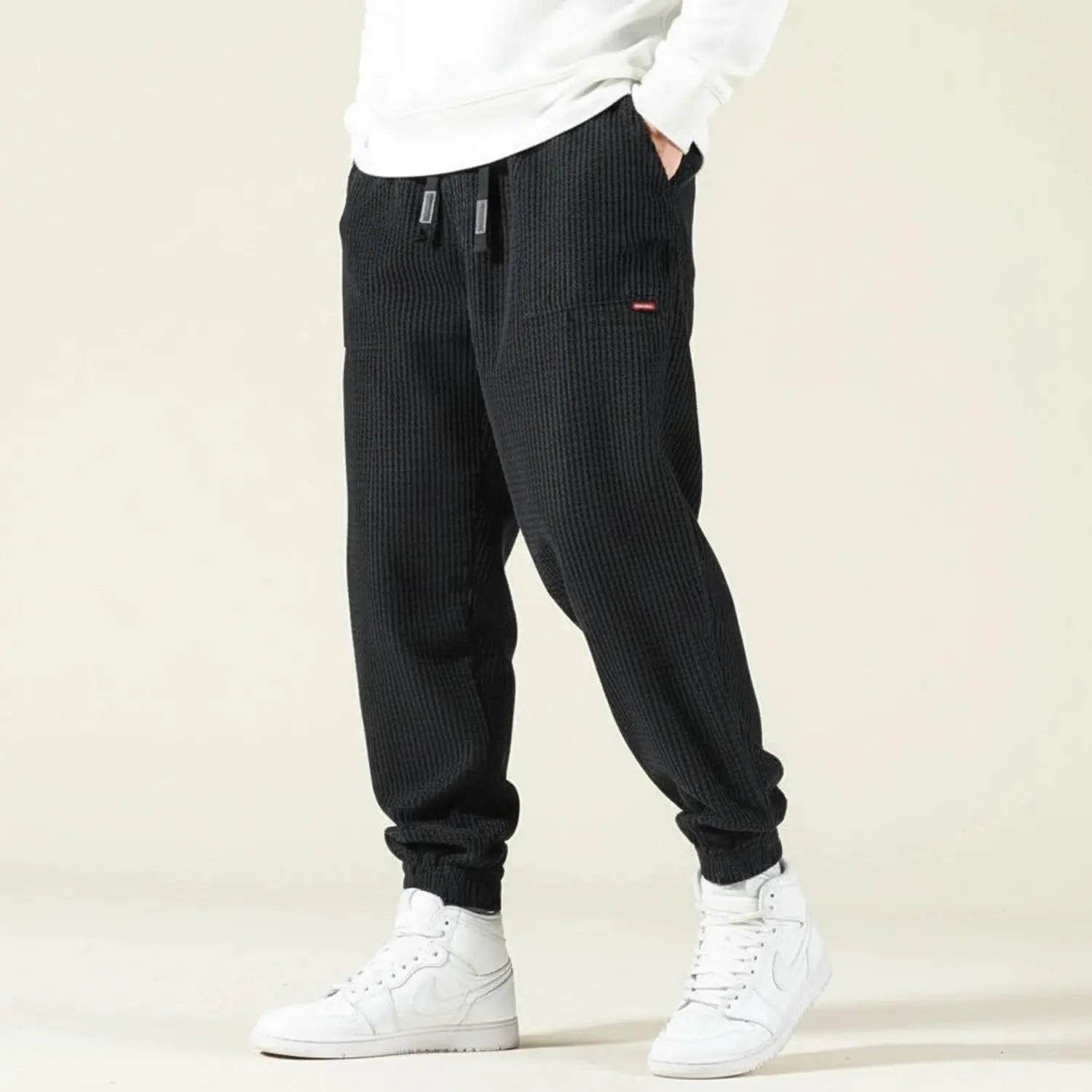 View of relaxed versatile jogger pants in dark gray, featuring an elastic waistband and tapered legs for comfort