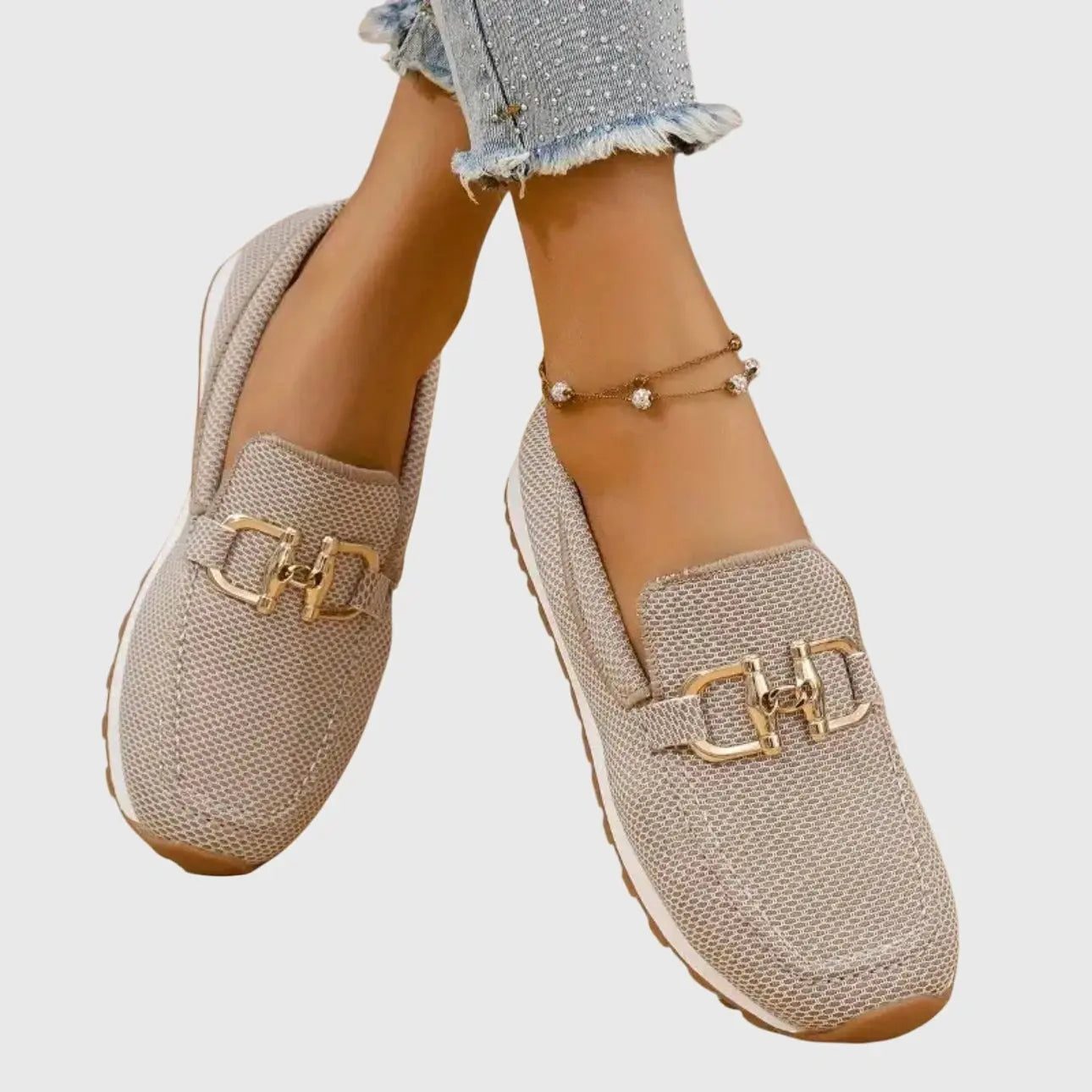View of chic slip on loafers in soft beige leather with a sleek silhouette and subtle stitching accents