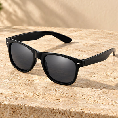 sunglasses — Black Charcoal eyewear, complete individual pair on warm neutral stone; front — view 2