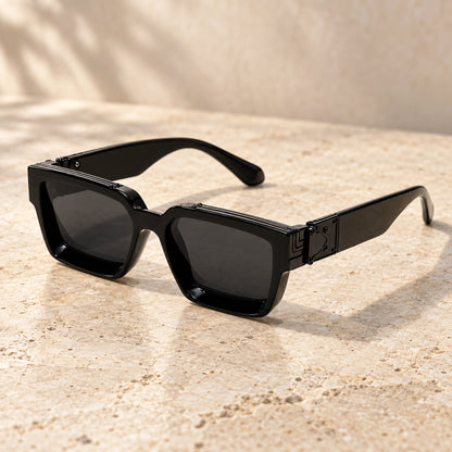 Small Black Charcoal sunglasses, complete pair on a warm neutral stone surface. — view 2