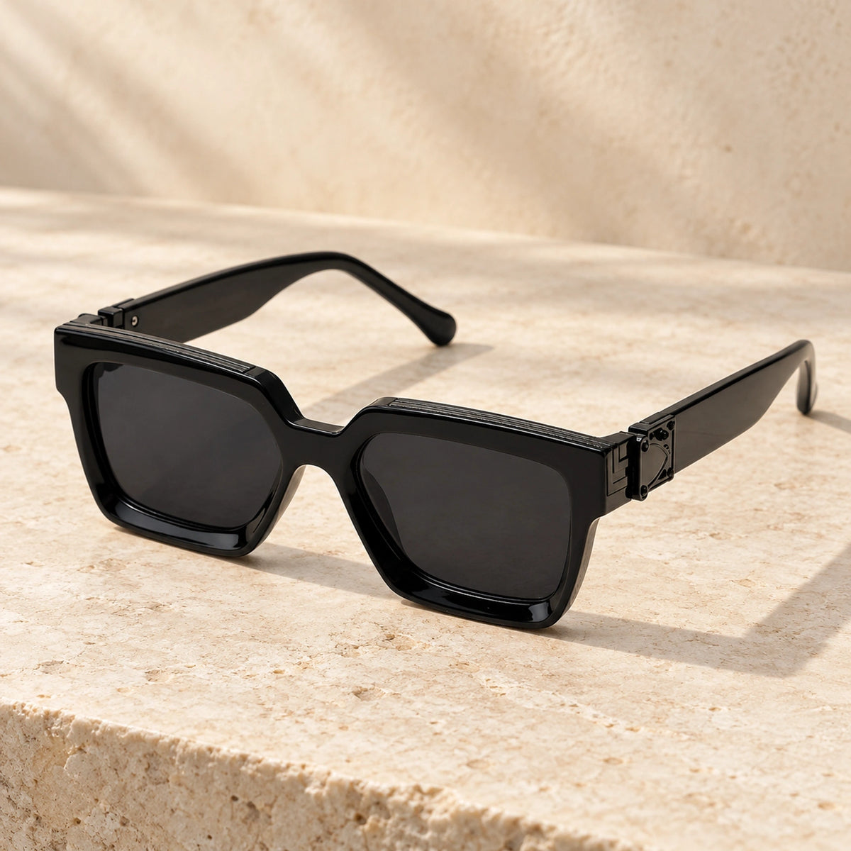 Medium Black Charcoal sunglasses, complete pair on a warm neutral stone surface. — view 5